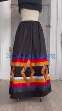 Load and play video in Gallery viewer, Seven golden diamonds adorn red, orange, gold, navy and black ribbons on a black skirt, 360 view
