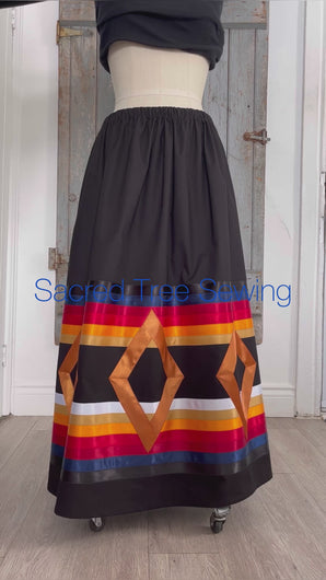 Seven golden diamonds adorn red, orange, gold, navy and black ribbons on a black skirt, 360 view