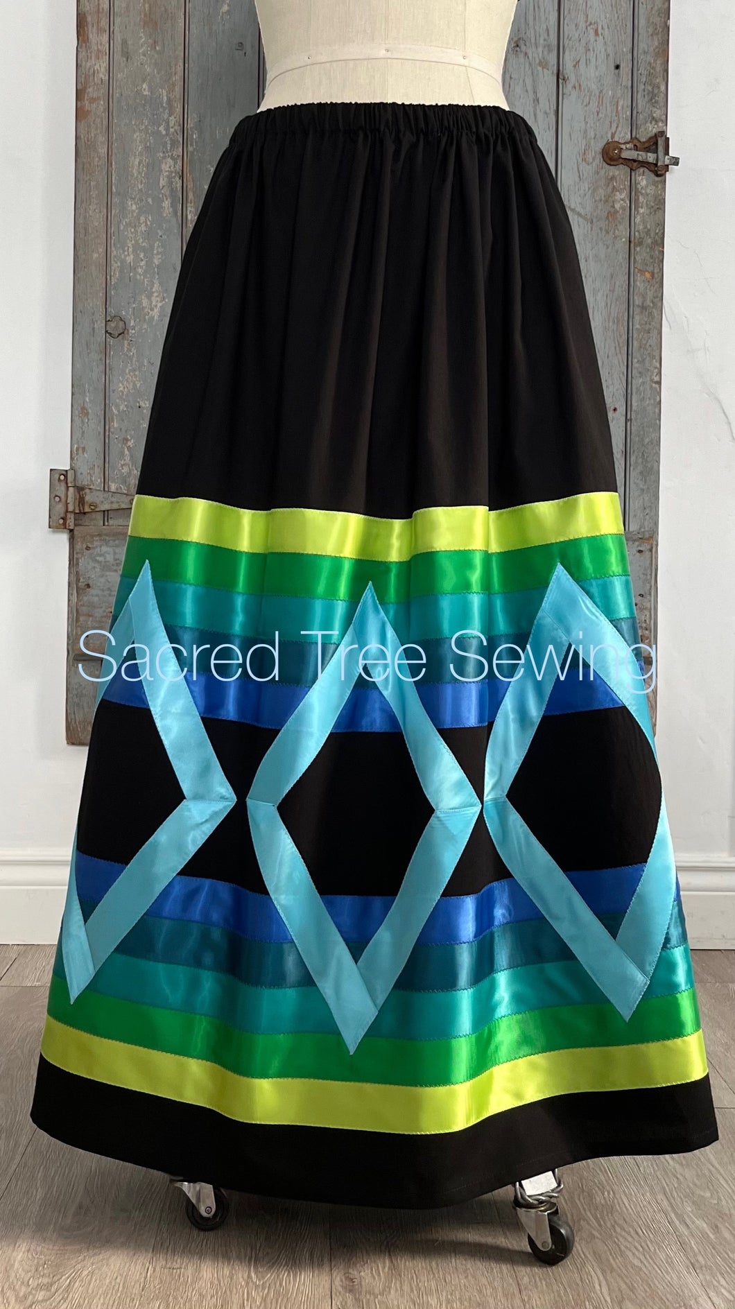 Vibrant blue and green ribbons on black fabric, front view