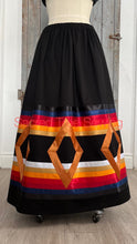Load image into Gallery viewer, Seven golden diamonds adorn red, orange, gold, navy and black ribbons on a black skirt, front view
