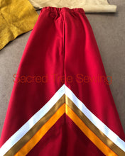 Load image into Gallery viewer, Pocket view of the Red rain skirt with red, orange, gold and white ribbons
